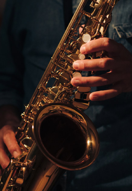 A close-up of hands playing a saxophone in a night club